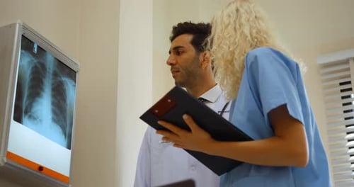 Doctors Analyzing X-Ray Scan in Hospital Room