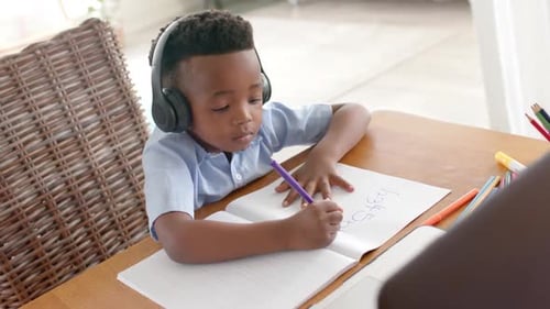 Boy Studying at Desk with Headphones in Home