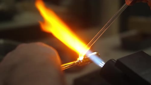Glass being melted on to artwork by glass blowing artist