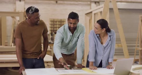 4k video footage of a team of designers working with blueprints in a workshop