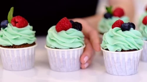 Cupcakes Garnished with Berries and Mint Leaves