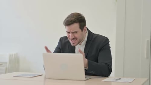 Businessman Reacting to Loss While Working in Office