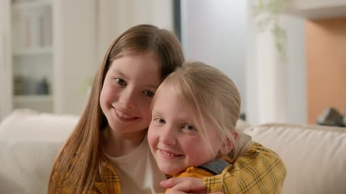 Two Cute Sisters Embracing, Bonding at Home