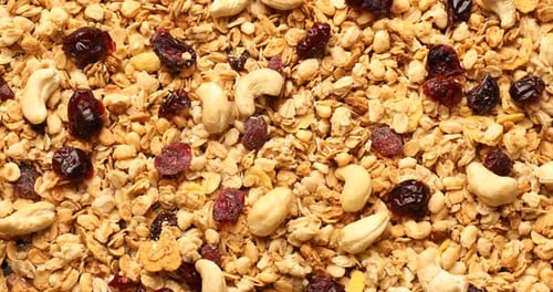 Tasty granola with dried fruits and nuts as background, top view