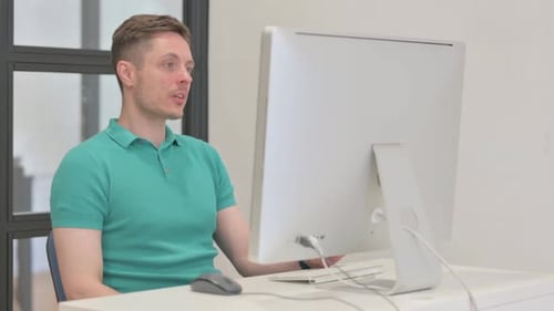 Young Adult Participating in Video Conference at Desk