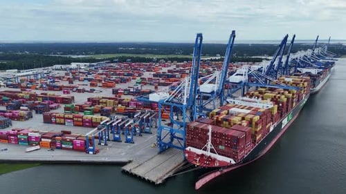 Aerial Drone View of Container Ship Docked at Busy Shipping Port with Cranes