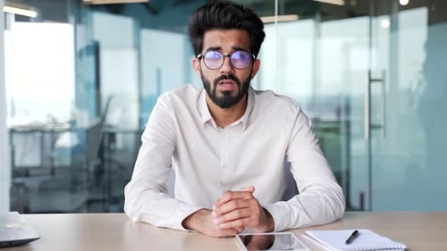 Webcam view Young bearded man watching video call training looking at camera while sitting