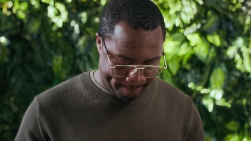 Young Concentrated Black Businessman Using Tablet at Green Workspace
