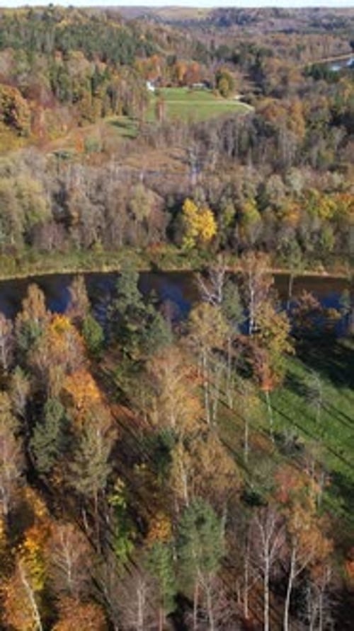 Autumn landscape with river bend and colorful foliage in rural area