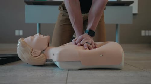 Health Worker Demonstrating CPR Of Mannequin. - close up