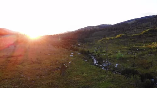 Aerial shot with sun flares in the lens of the course of a river in the Grand Teton Park.