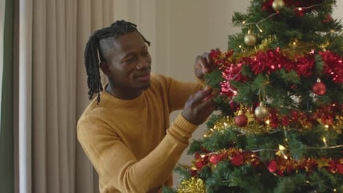 Man Decorating Christmas Tree at Home for Holiday