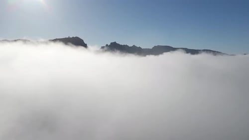 Flying above the clouds - amazing view of the clouds and the peak of the mountains on a sunny day. B