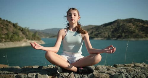 Teen Meditating Outdoors Near Lake