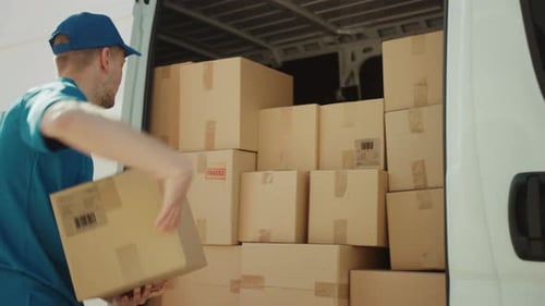 Man Unloading Delivery Boxes From White Delivery Van