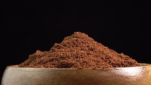 Dark Brown Powder in a Wooden Bowl