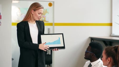 Businesswoman Presenting Financial Data to Colleagues