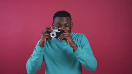 Likable African Guy in Mint Sweater Looking at Model Young Attractive Man with Beard Holding Camera