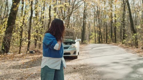 A Woman Makes a Phone Call on the Road Alone During a Car Breakdown