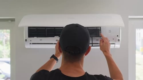 Man Installs Air Conditioner Filter in Home