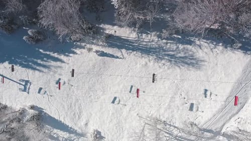 Ski Lift Moving Uphill Over Snowy Mountain Slope in Winter