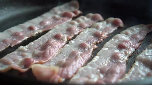 Slices of Bacon Cooking in a Pan