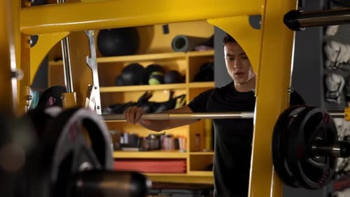 Focus muscular sportsman training biceps with six pack of abs, performing snatching heavy barbell sq
