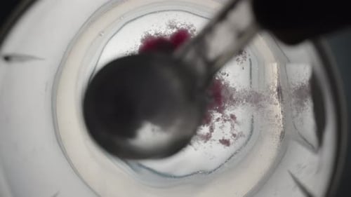 Top View: Powder Of Dietary Sports Supplement With Creatine Is Poured Into A Glass And It Turns.