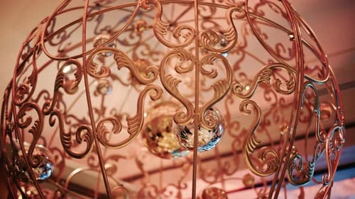 Close up of decorative Christmas ornaments hanging from an ornate metal structure