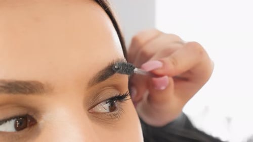 Closeup of Brushing Eyebrows The Eyebrow Master Adjusts the Shape The Beautician Works in a Beauty
