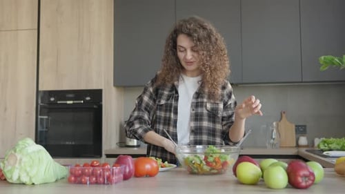 Woman Making Fresh Salad in Modern Kitchen