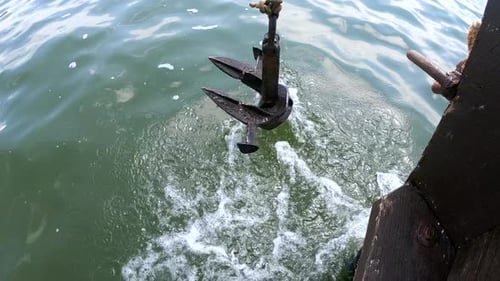 Alter rostiger Anker zum Aufhängen, Taumeln am Bug des Hecks, schwimmendes Holzschiff