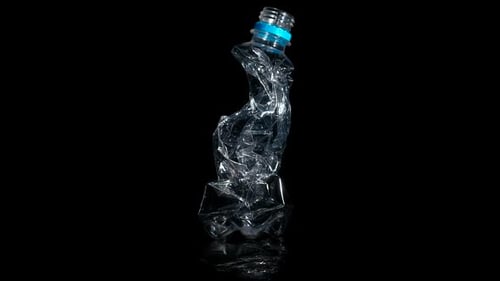Crumpled Plastic Bottle Rotating on Dark Surface