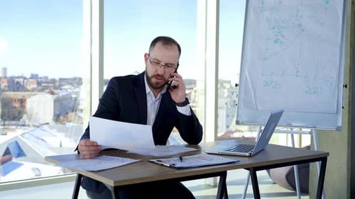 Serious businessman working with documents. Man working everyday job at modern office
