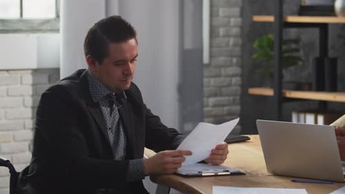 Two Colleagues Discussing Business Documents in Modern Office