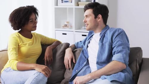 Woman and man talking to each other on sofa