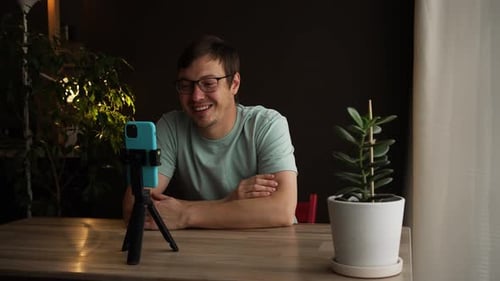 Man Video Calling on Smartphone at Table Indoors