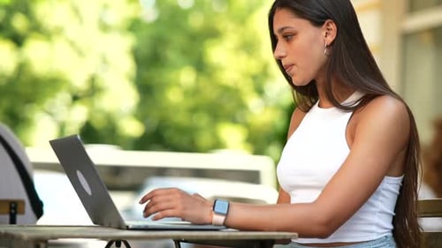 Beautiful Woman Working on Laptop at Outdoors Cafe