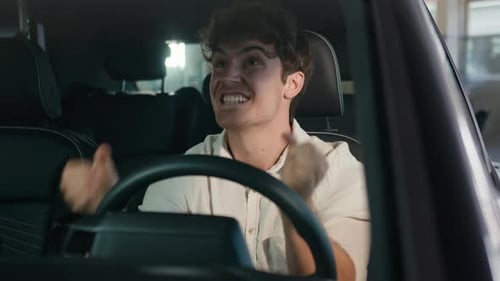 Young Man Sitting in Car Expressing Excitement