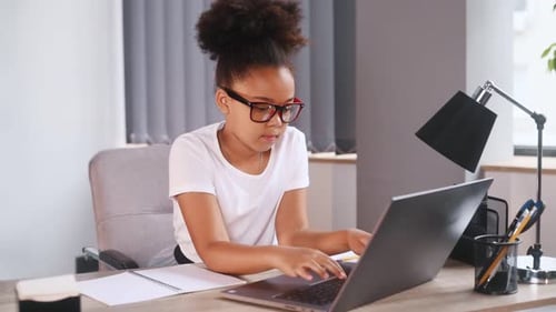 Child Typing on Laptop Computer at Home