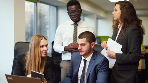 Diverse Office Corporate Workers Discuss Project on Laptop Display in Office Multiethnic People