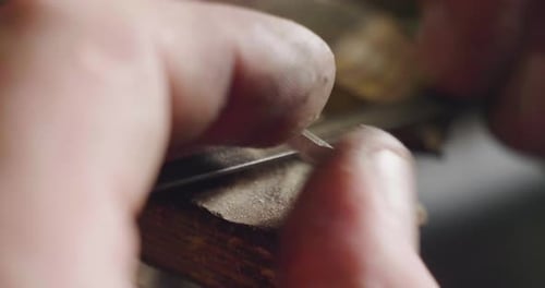 Makro eines Goldschmieds, der den Stahl schneidet und feilt, um einen Ring herzustellen. Konzept: Silber, Stil, Produkte