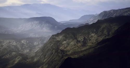 Stunning Landscape View of Rolling Mountains and Valleys Under Cloudy Sky