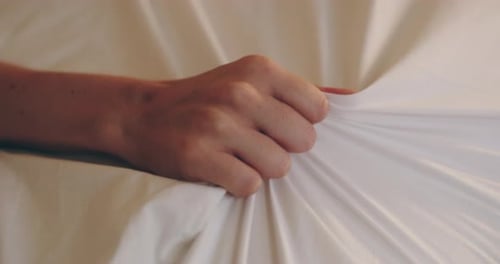 4K video footage of an unrecognizable woman’s hand grabbing a sheet in pleasure