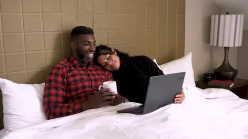 Couple Lying in Hotel Bed with Laptop Adult