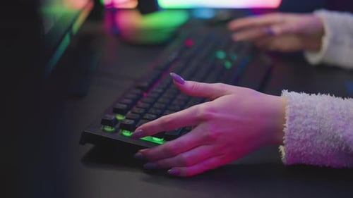 Hands Typing on a Lit Gaming Keyboard