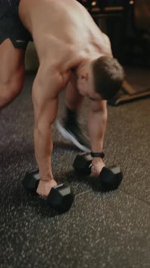 Muscular Man Performing Dumbbell Thruster Exercise in Gym