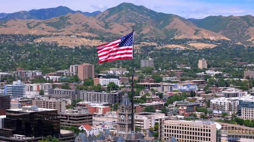 Aerial View of American Flag Waving Over Cityscape