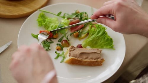 Overhead view of person eating salad and pate