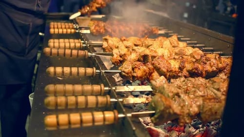 Delicious shish kebab cooking on a rotating barbecue skewer street food